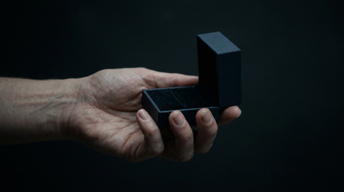 single hand holding an open but empty ring box conveying loss, betrayal after you found out wife cheated.