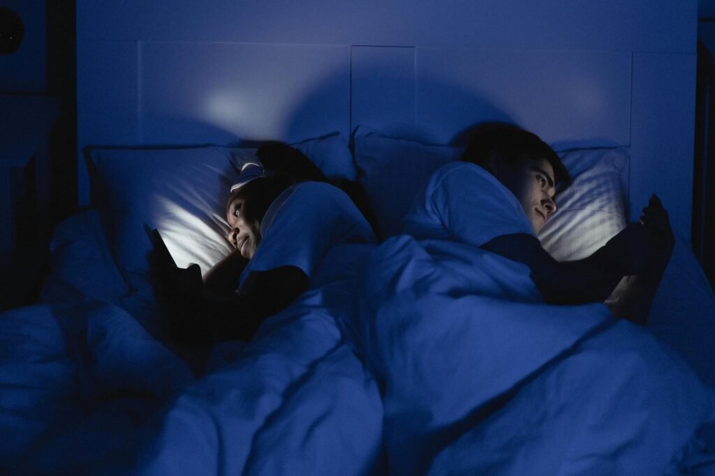 Couple lying Back to Back in Bed Using Smartphone after someone cheated